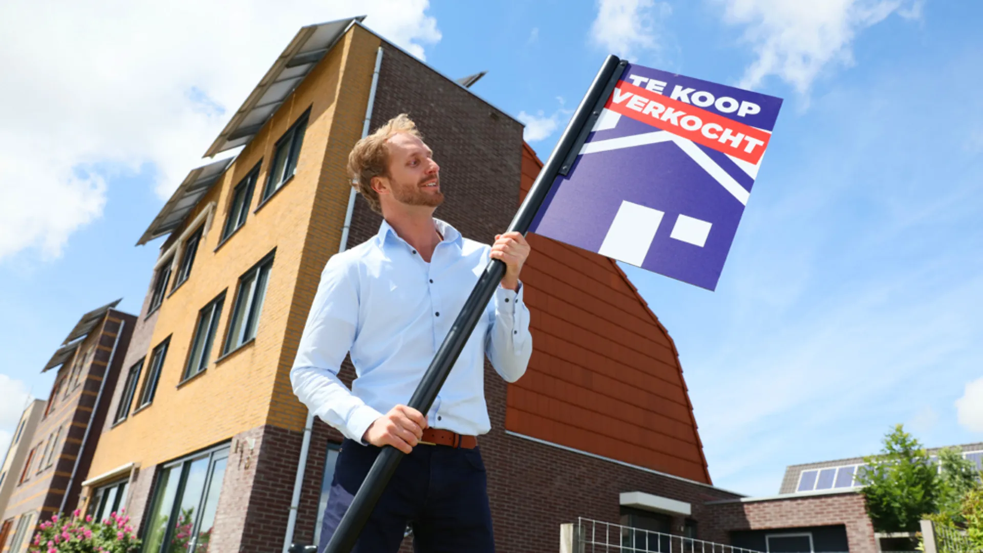 Persoon zet verkocht bord in de grond