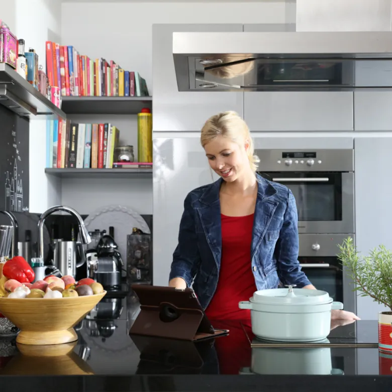 Persoon staat in keuken op tablet te kijken