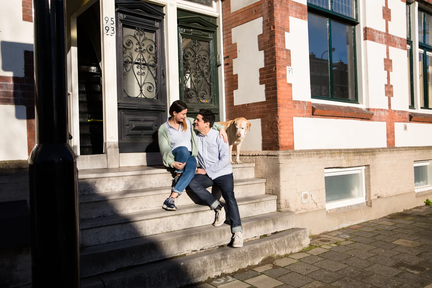 Twee personen zitten voor de deur op een trap